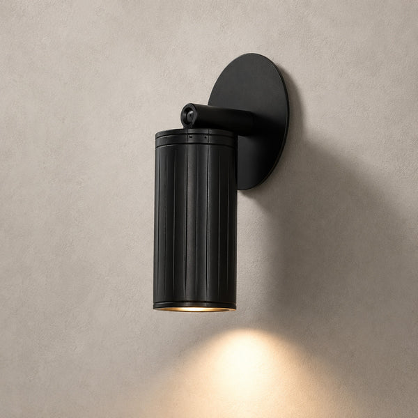 Luminar matt black adjustable wall spotlight angled down, lit