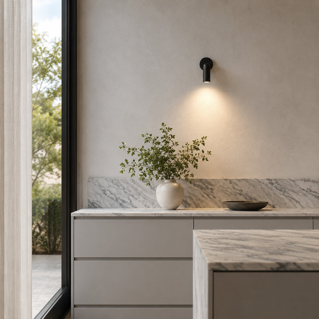 Luminar black spotlight washing light over a marble worktop and vase