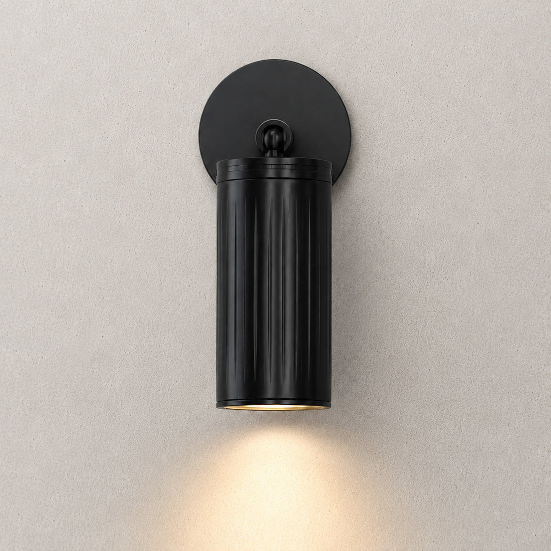 Luminar black ribbed cylinder spotlight casting a downward beam
