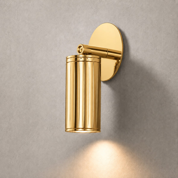 Luminar brushed brass adjustable wall spotlight angled down, lit