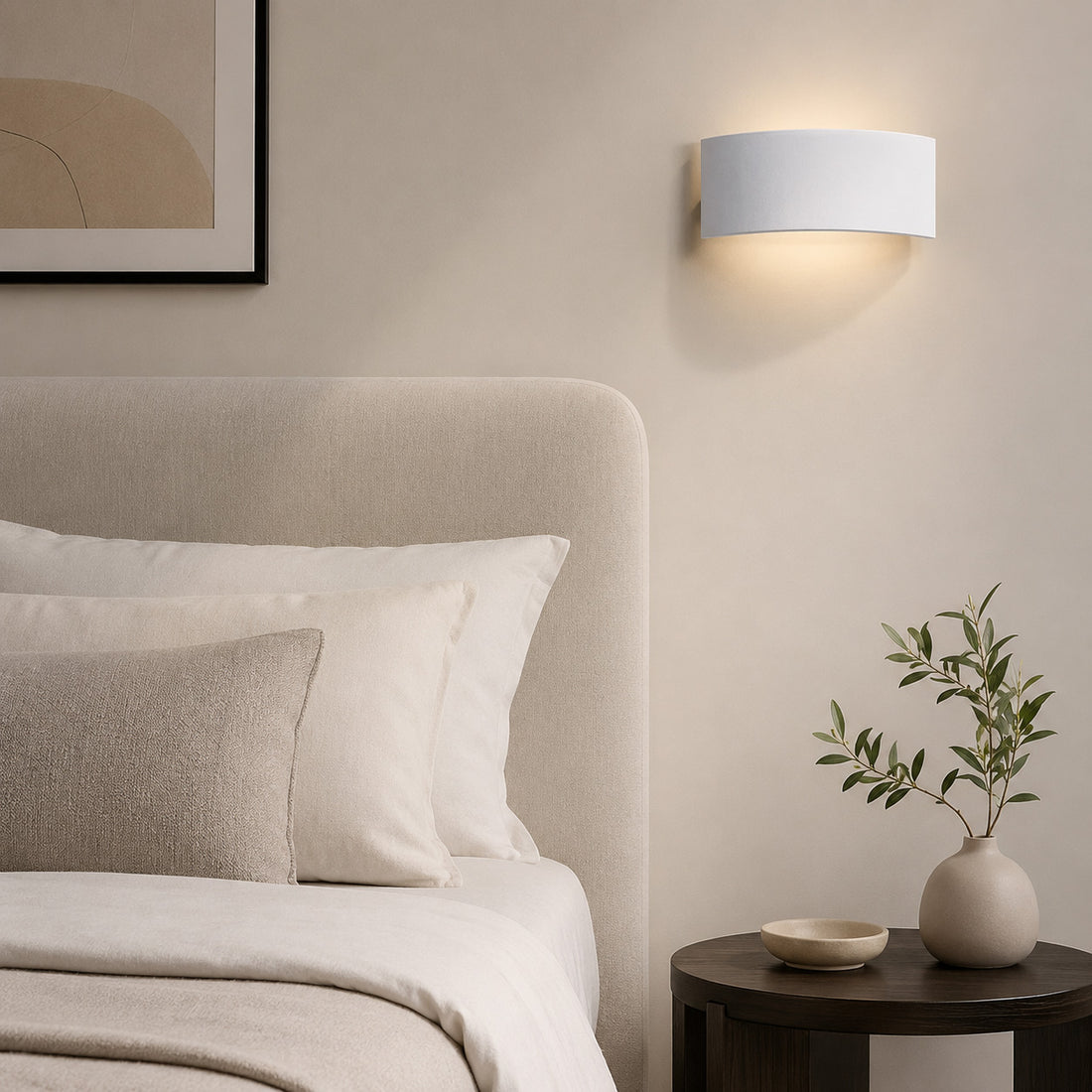 Mood paintable plaster wall light lit above an upholstered headboard