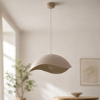 Nami sand taupe wavy metal pendant light hanging in a neutral room with framed art