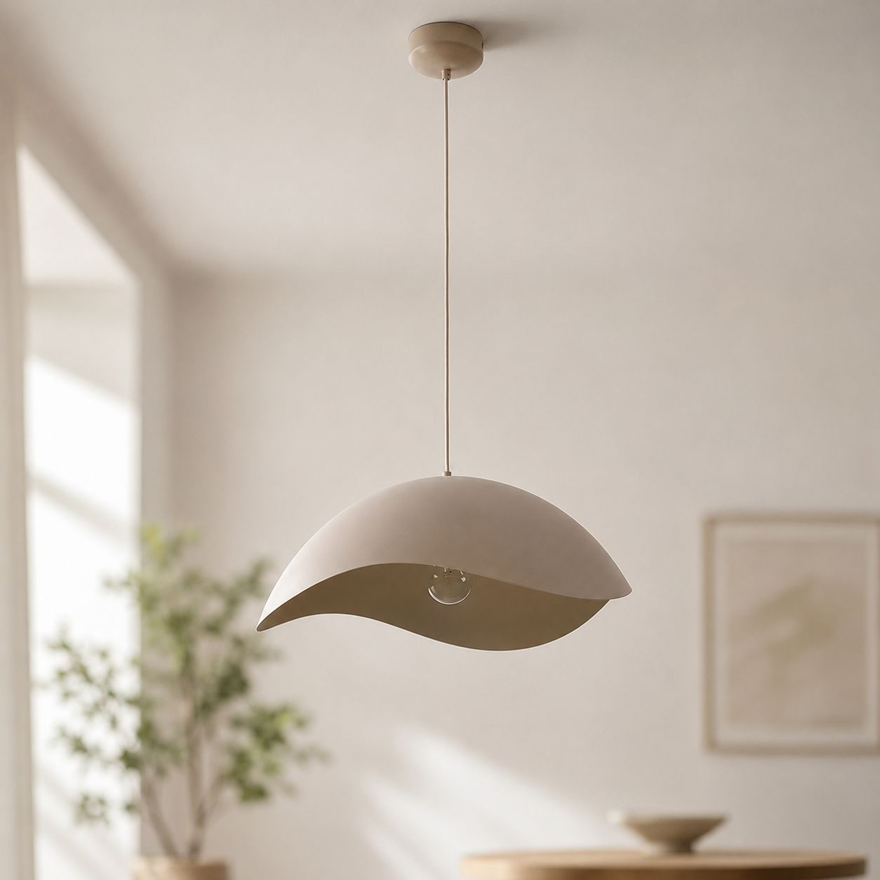 Nami sand taupe wavy metal pendant light hanging in a neutral room with framed art