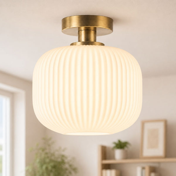 Rivoli antique brass semi-flush ceiling light with white ribbed glass shade, lit