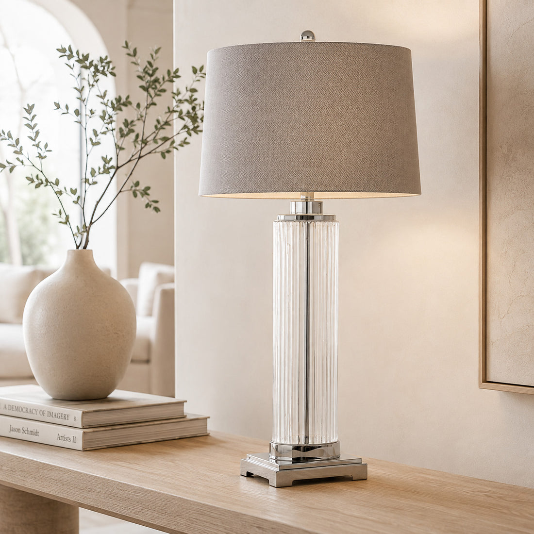 Roma glass column table lamp with chrome base styled beside a stone vase