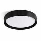 Senna black ribbed LED flush ceiling light, angled view on white