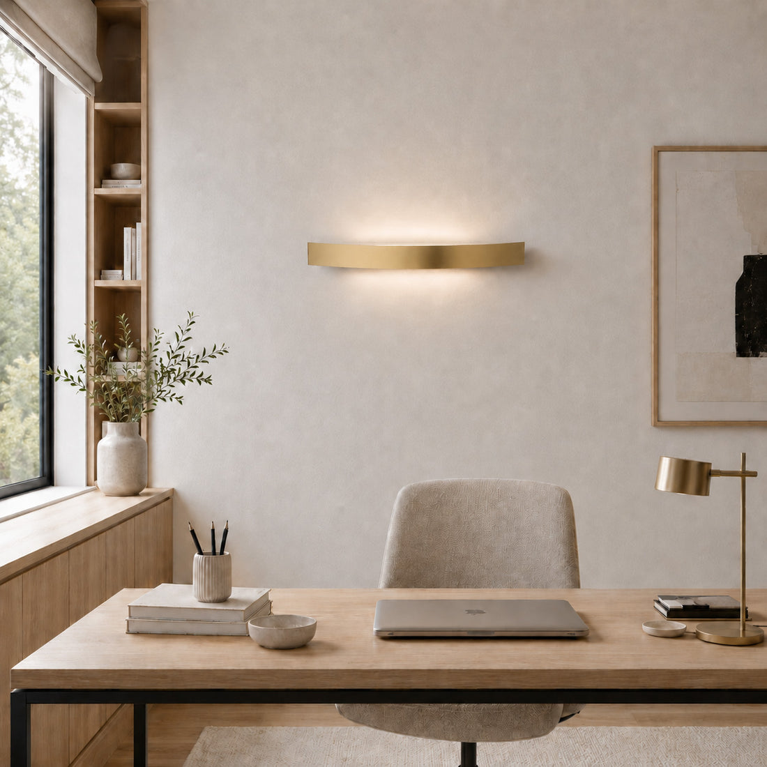 Spoiler satin gold wall light lit over a home office desk by a window