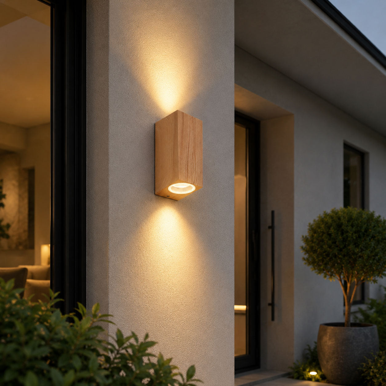 Talia wood-effect up and down wall light lit beside a front door at dusk