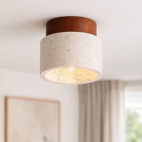 Tavira natural stone flush ceiling light with dark wood top, lit on a white ceiling