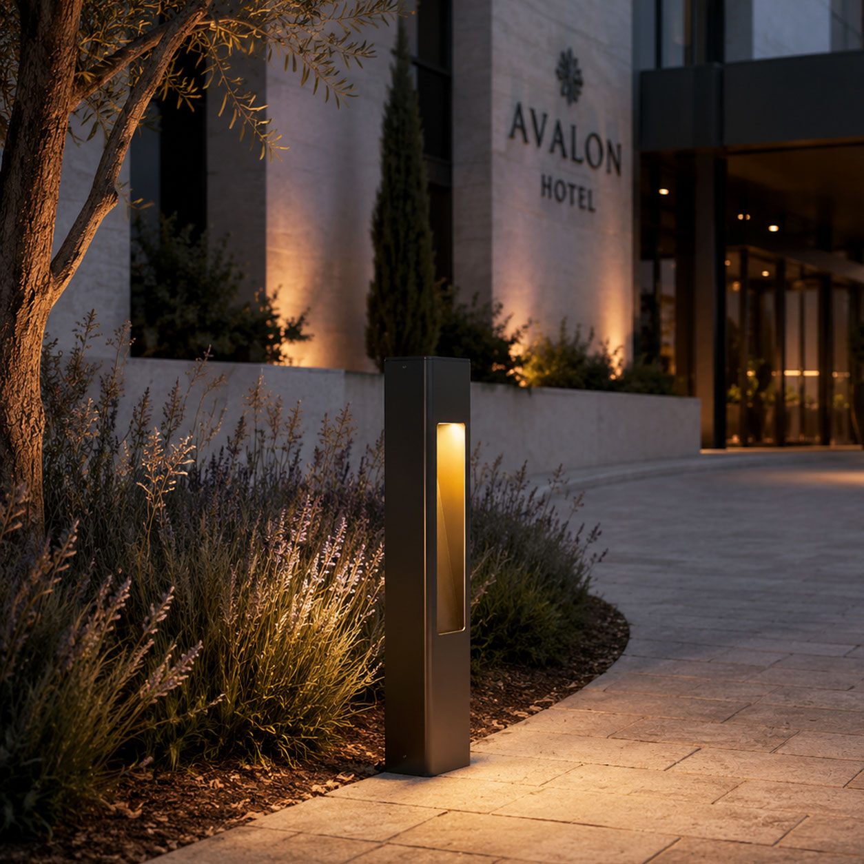 Torino anthracite bollard lights lit beside a hotel entrance path at dusk