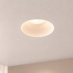Matt white Kanto fixed trimless downlight nearly invisible in a plastered ceiling