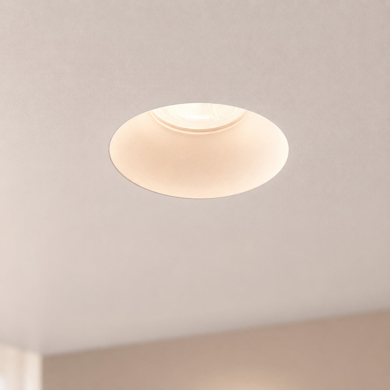 Matt white Kanto fixed trimless downlight nearly invisible in a plastered ceiling