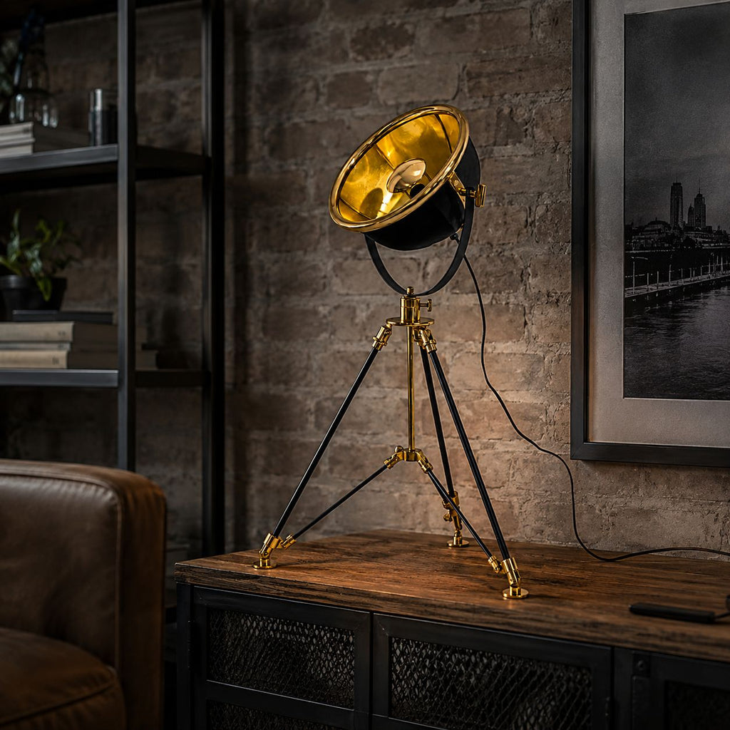 Valen black and brass tripod table lamp on a sideboard against exposed brick