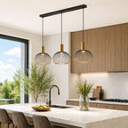 Velia black and gold triple cage pendant over a kitchen island in daylight