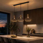 Velia 3-light cage pendant lit above a kitchen island at dusk