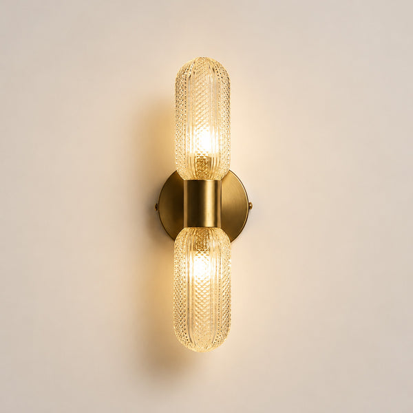 Verona double capsule sconce lit straight-on showing brass backplate