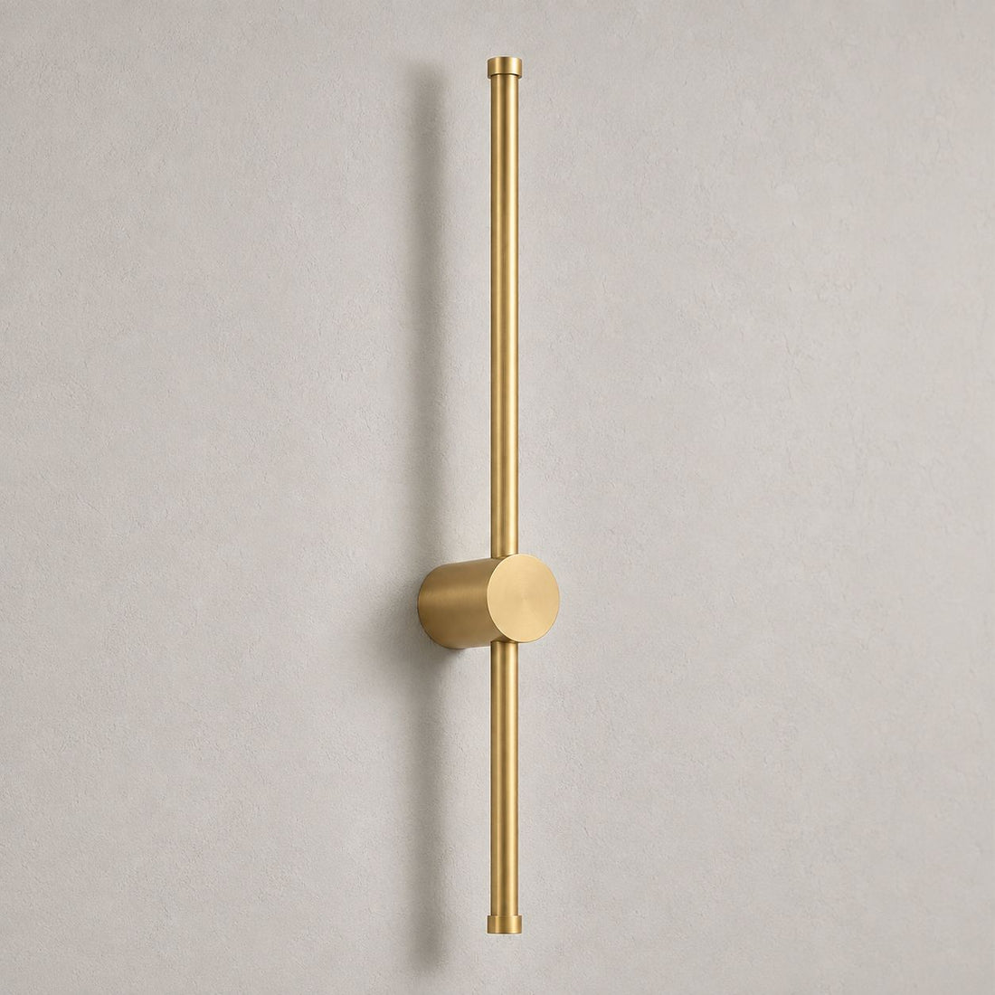 Vireo brushed gold vertical LED stick wall light on a white wall in daylight