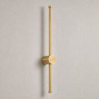Vireo brushed gold vertical LED stick wall light on a white wall in daylight