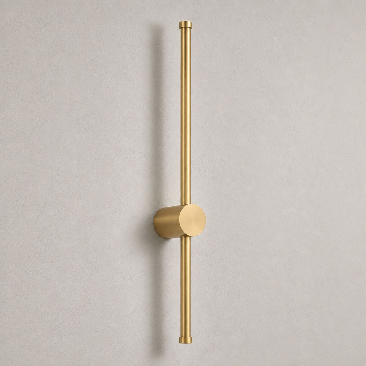 Vireo brushed gold vertical LED stick wall light on a white wall in daylight