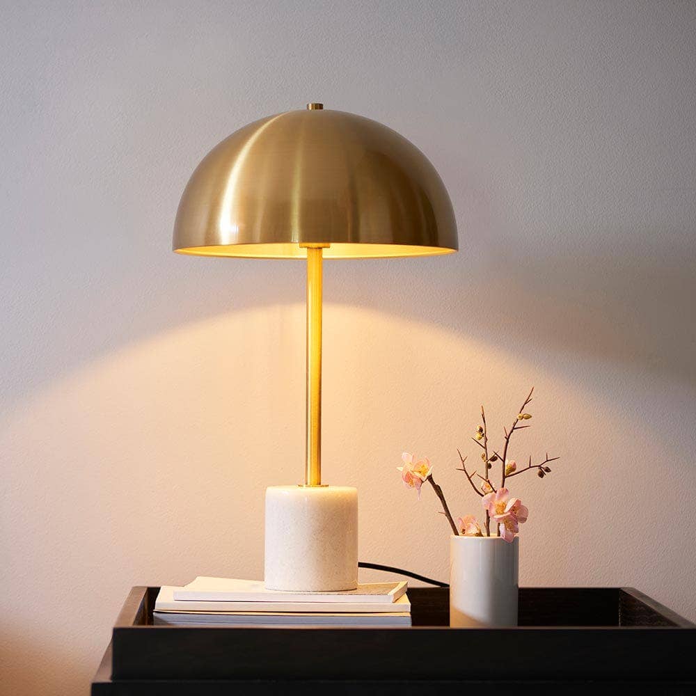 Camilla gold and marble table lamp with fabric shade on bedside table