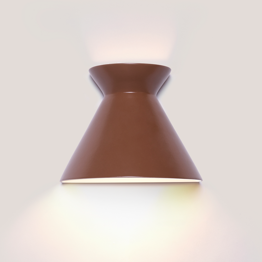 Kiro small russet brown ceramic wall light casting light up and down
