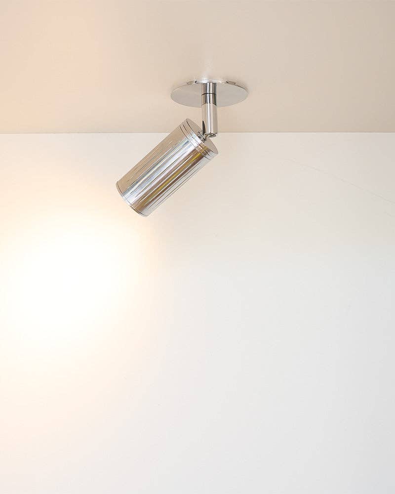 Close-up of precision-engineered steel spotlight fixture in matt chrome