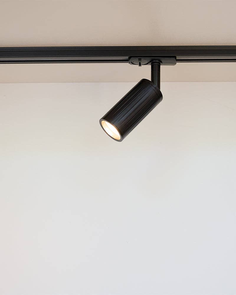 Luminar black track mounted spotlight on white ceiling