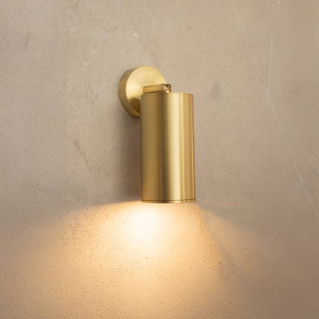 Ravenna single wall sconce in antique brass finish mounted on white wall