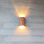 Handmade Portuguese wall light in warm terracotta creating soft shadow patterns