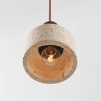 Single travertine pendant light illuminated showing soft ambient glow