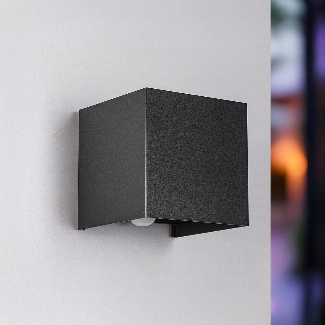 Ward LED wall light in black finish with integrated dusk to dawn sensor