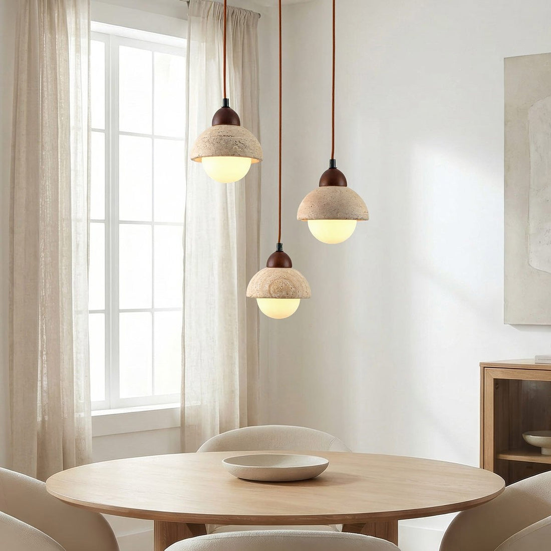 Sabbia three light round pendant with travertine and glass shades suspended at varying heights