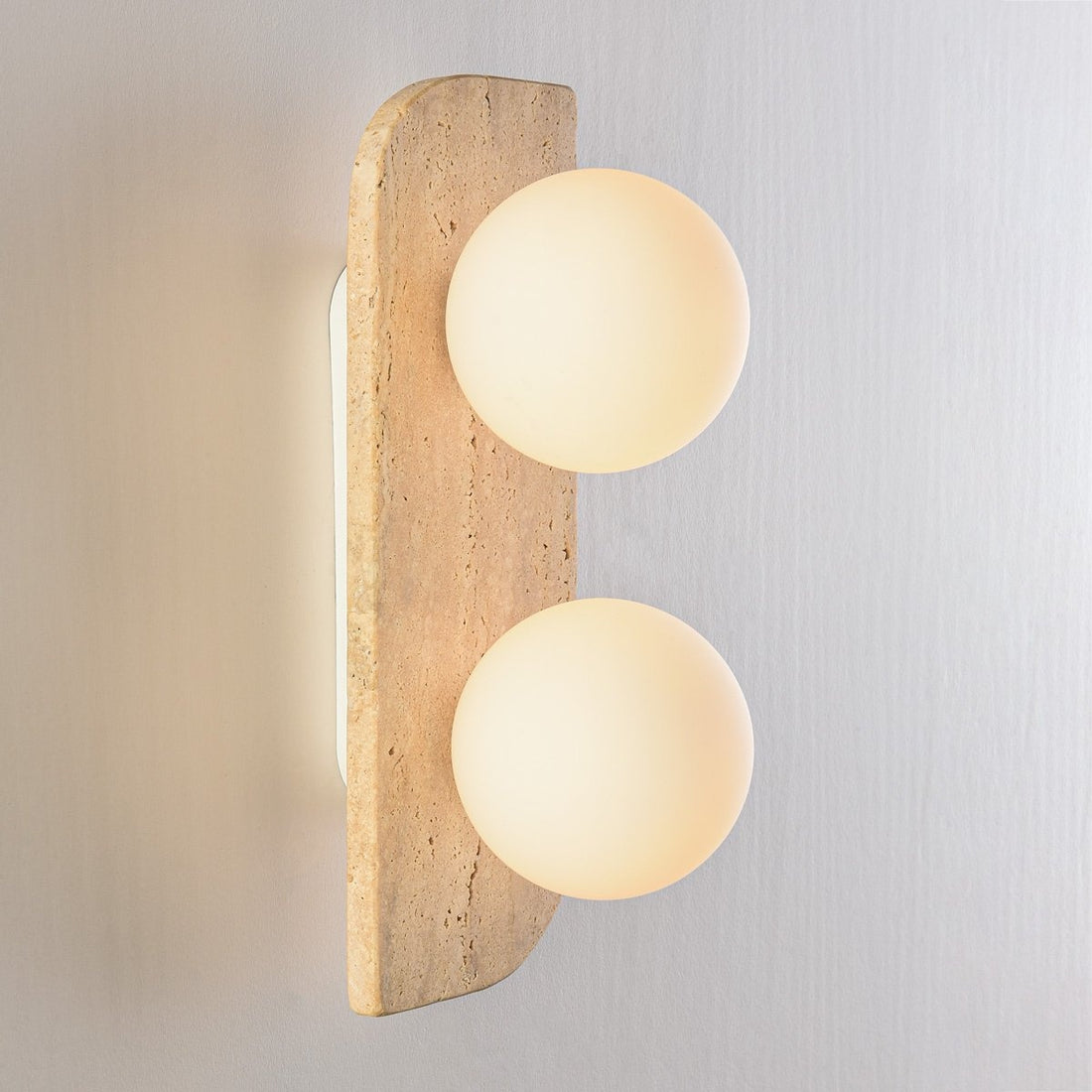 Orla wall light illuminated showing warm ambient glow through twin glass globes