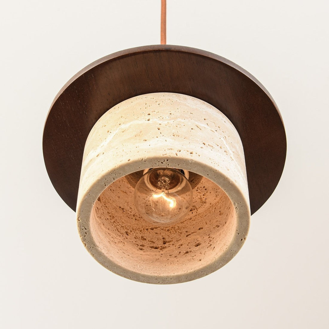 Hoshi travertine and wood pendant light with rounded shade hanging in modern interior
