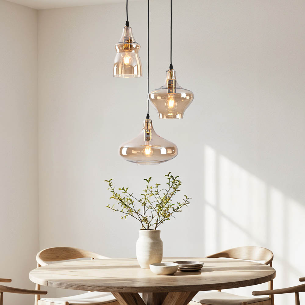 Black and amber triple pendant light hanging in modern kitchen dining area