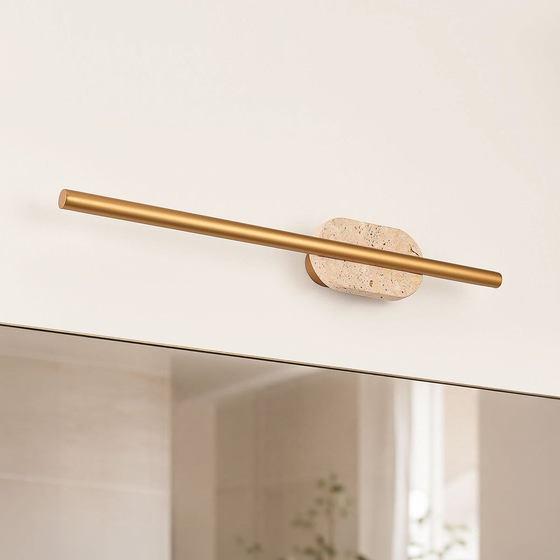 Close-up of Isola wall light showing travertine stone detail and gold finish