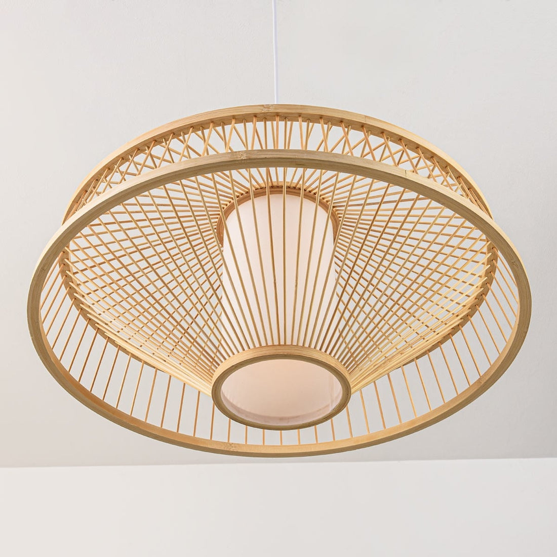 Natural bamboo Oki pendant light casting decorative shadows on ceiling and walls
