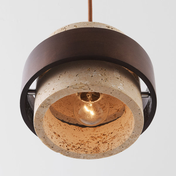 Tsumi travertine and wood pendant light suspended over dining table