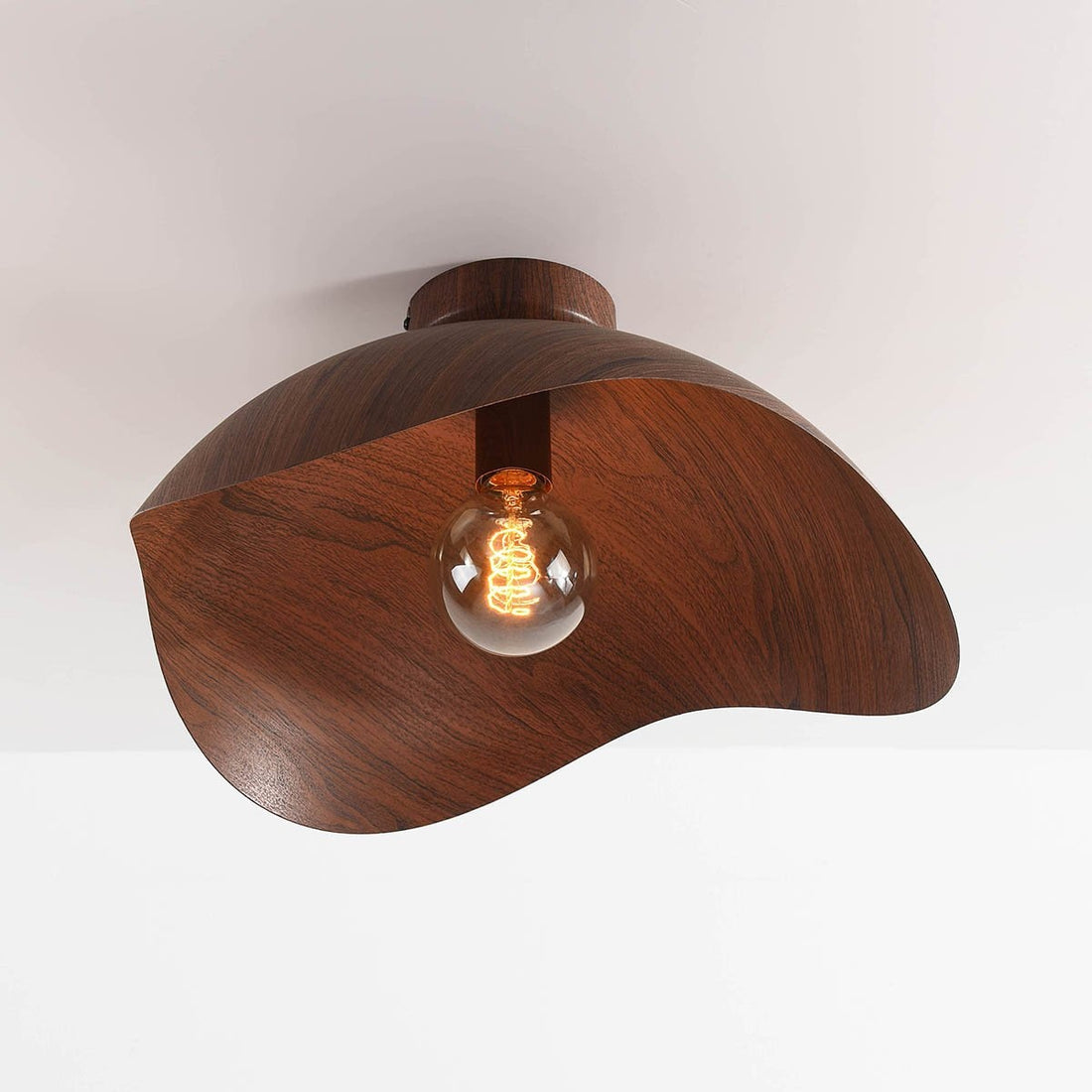 Nami walnut ceiling light illuminated showing shadow patterns on ceiling
