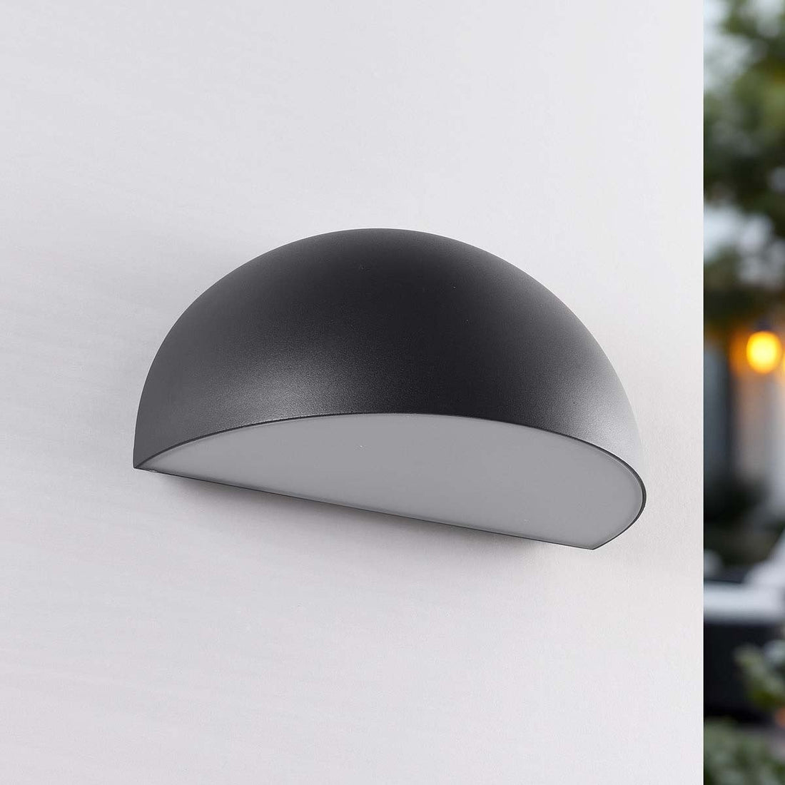 Bay outdoor wall light creating indirect glow on home exterior at dusk