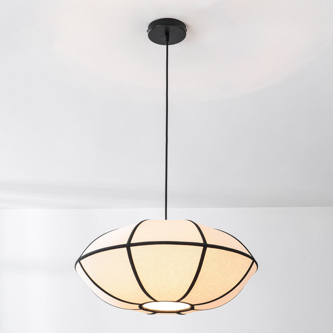 Ren pendant light illuminated showing warm diffused glow through linen shade