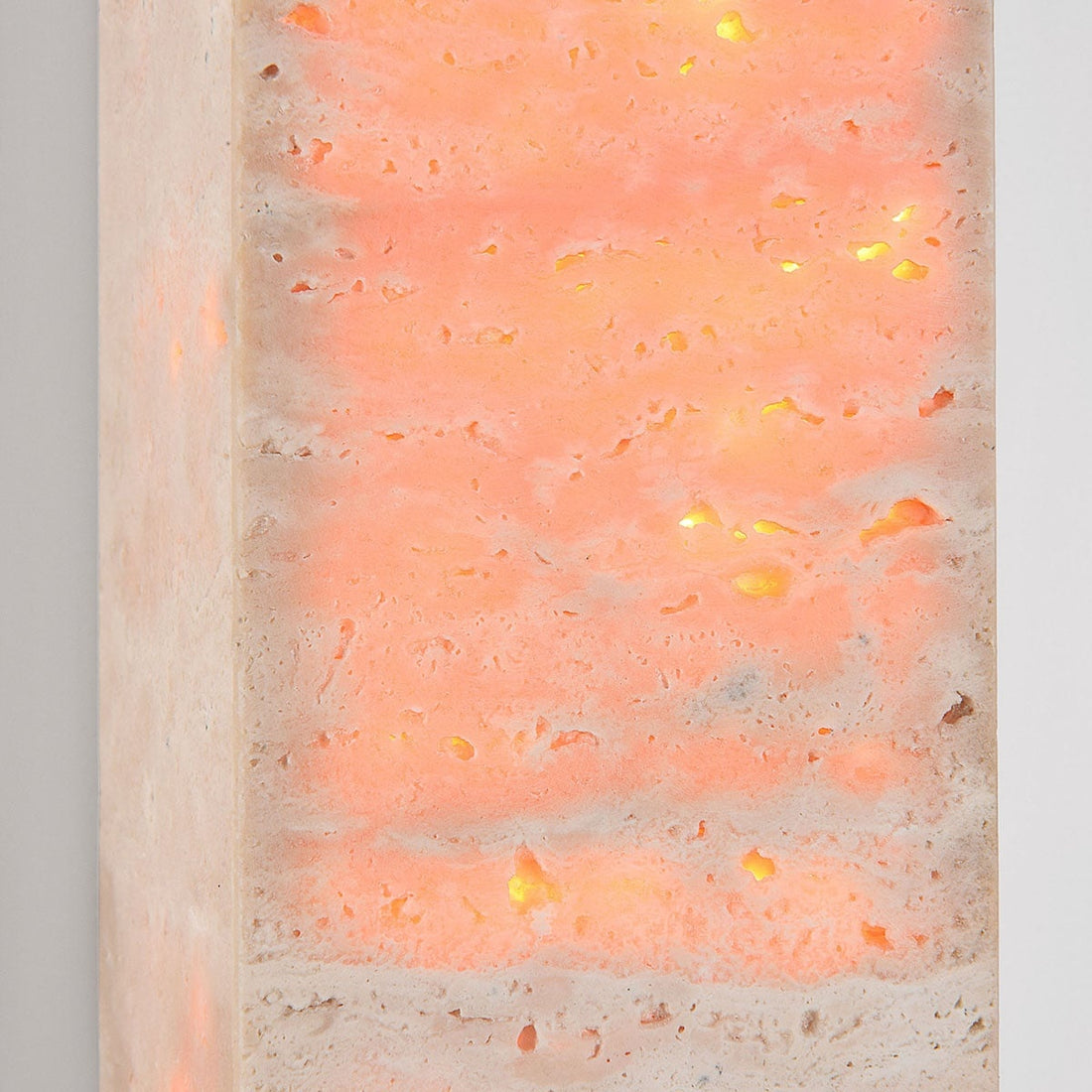 Sand beige travertine wall light illuminated showing upward and downward light effect
