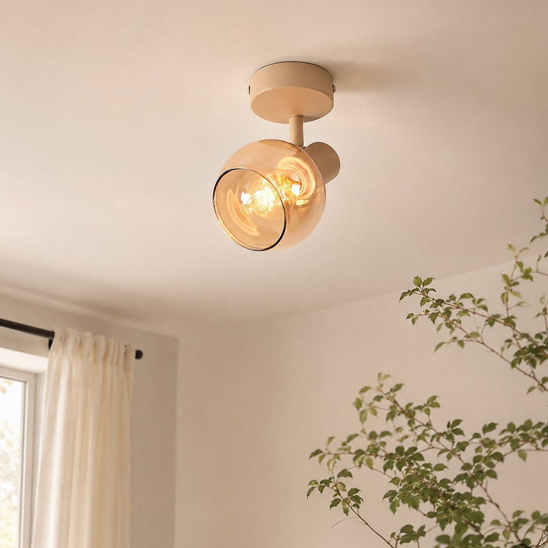 Beno adjustable ceiling spotlight with beige mount and amber glass shade