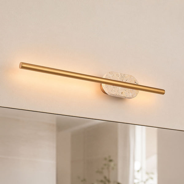 Isola LED bathroom wall light with brushed gold bar and travertine base mounted above mirror