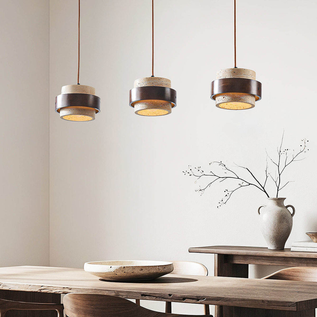 Tsumi travertine and wood three light linear pendant suspended over dining table