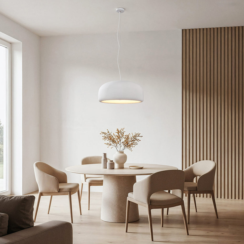 White disc pendant light suspended above modern dining table