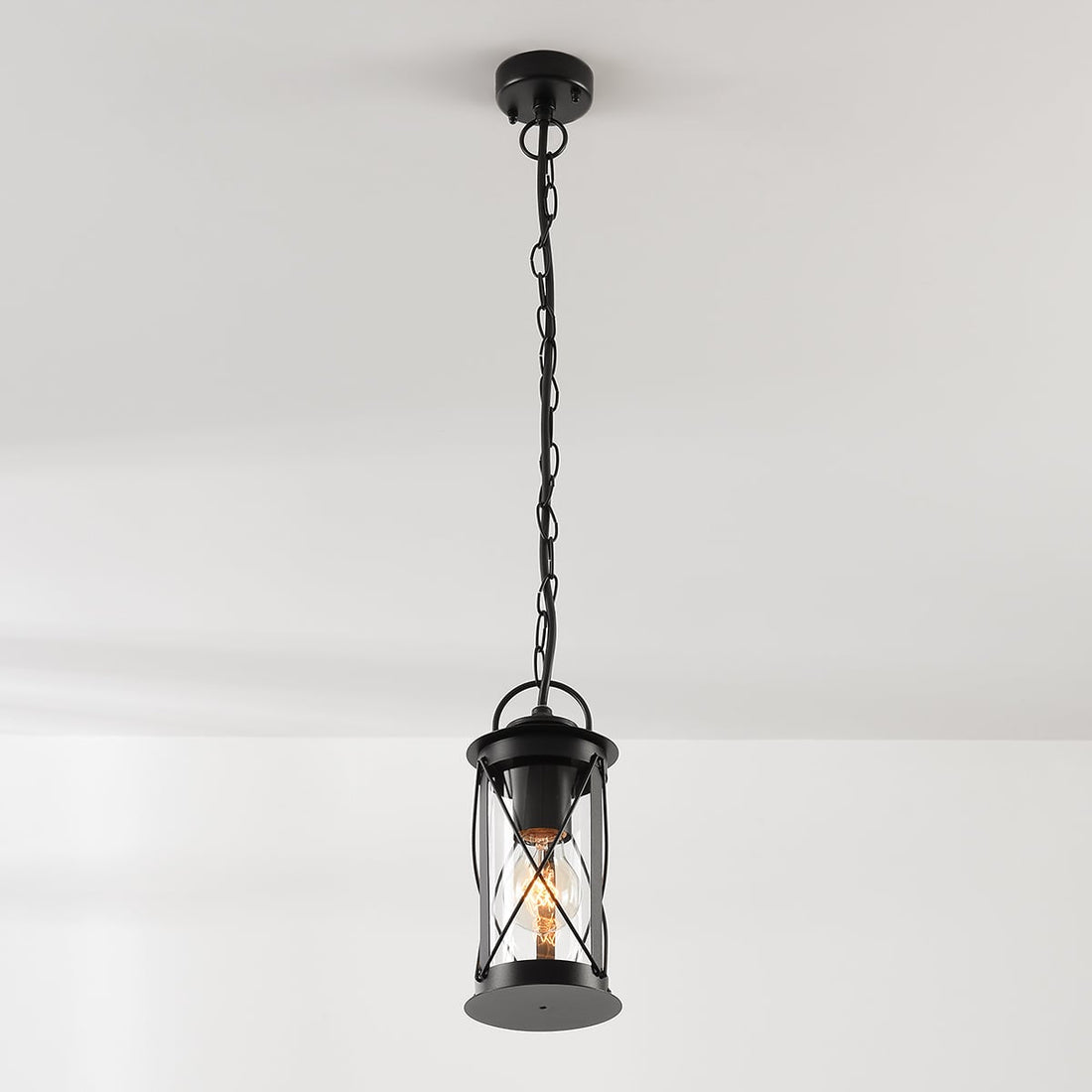 Malmo black outdoor pendant lantern lit on its link chain
