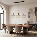 Close-up of Velia pendant light showing industrial cage design with gold interior