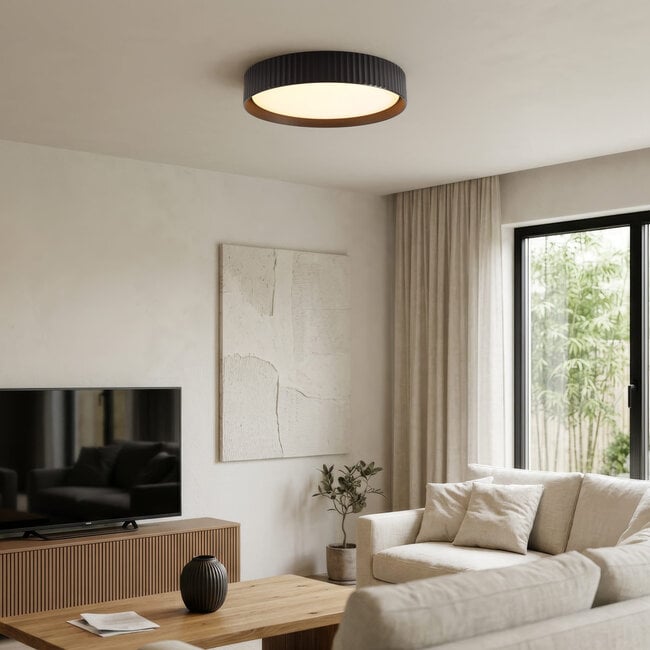Senna black flush mount ceiling light illuminated in modern living room