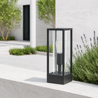 Ted black outdoor post lantern on a white rendered wall with lavender in daylight